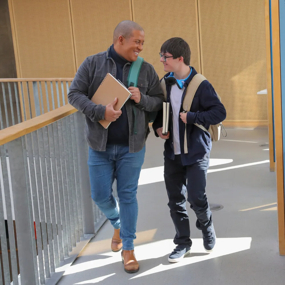 Support worker and disabled man walking and smiling together